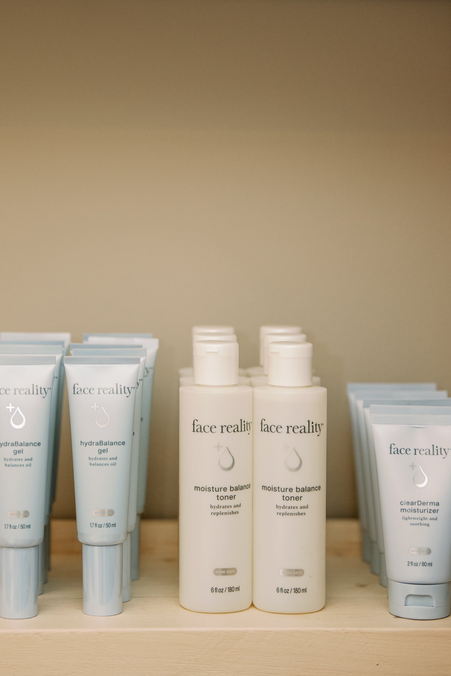 Face Reality skincare products displayed on a wood shelf in the McHenry, IL studio
