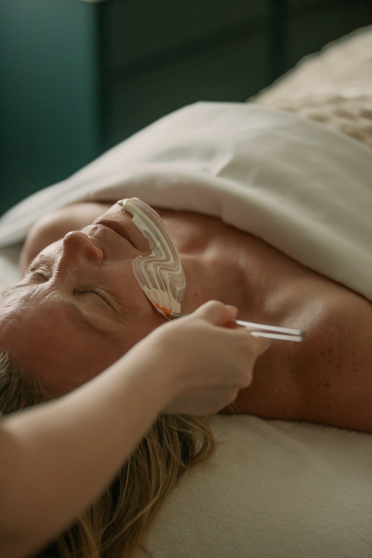 Client wearing protective goggles during a treatment with a handheld skincare device