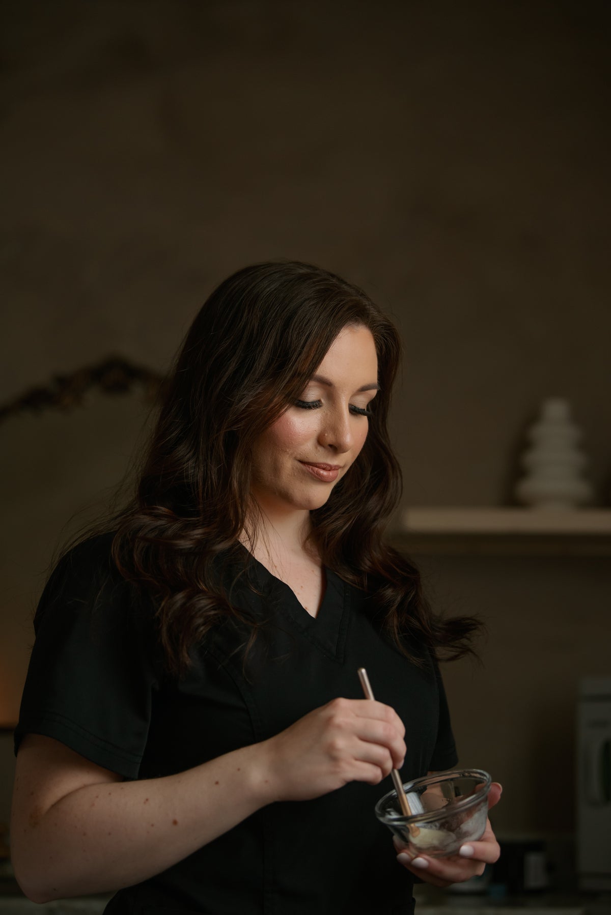 Felicia, esthetician at Esthetics With Me, mixing a custom treatment mask at the studio counter