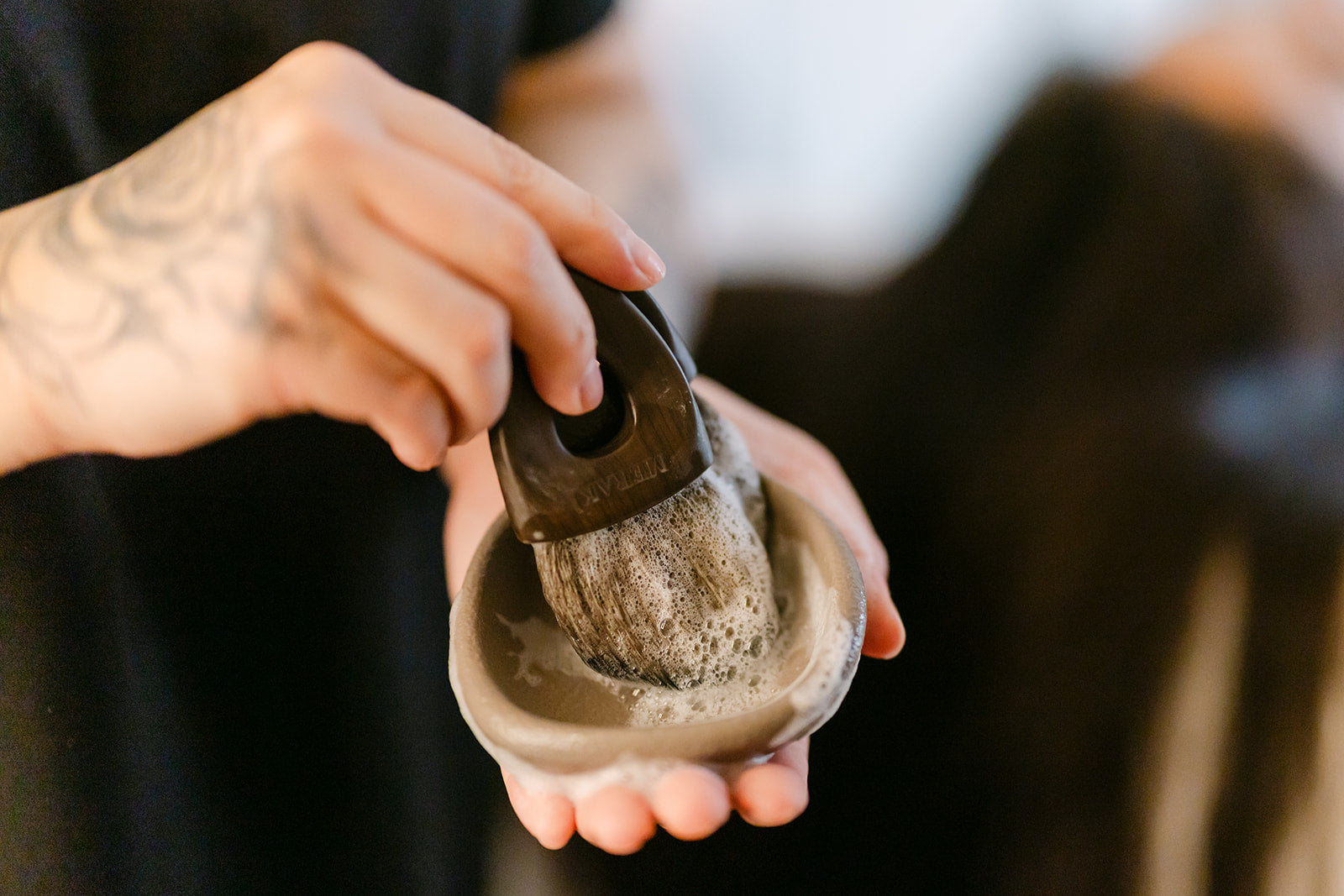 Esthetician holding a mask brush and bowl, ready to begin a facial treatment