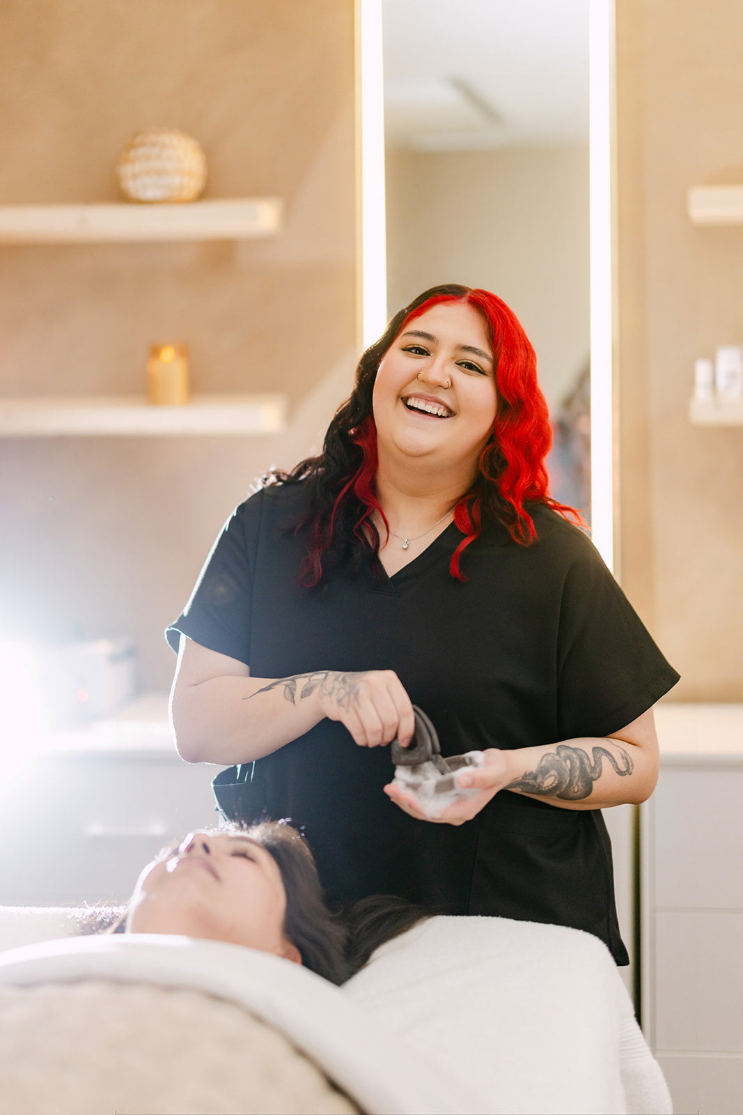 Yanelli, esthetician at Esthetics With Me, smiling warmly while mixing a mask for a client